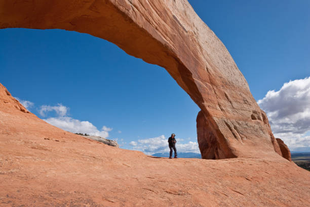 istock Woman Standing Under Wilson Arch 1155557879