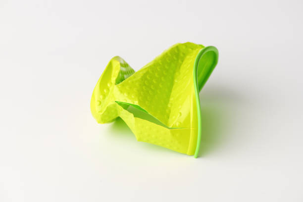 istock Green disposable plastic Cup broken lies on white background. Isolated background. Cup with pimples. 1155562065