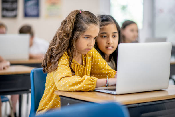istock Elementary school girl at a desk 1155565114
