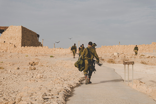 MILITARY TRAINING ZONE. Israeli soldiers walking through the territory of Masada fortification after war games. Masada, Israel: 23 October 2018