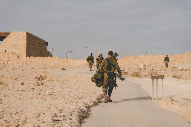 MILITARY TRAINING ZONE. Israeli soldiers walking through the territory of Masada fortification after war games. Masada, Israel: 23 October 2018. MILITARY TRAINING ZONE. Israeli soldiers walking through the territory of Masada fortification after war games. Masada, Israel: 23 October 2018 war zone stock pictures, royalty-free photos & images