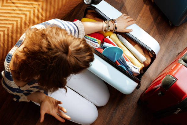 istock furious modern woman closing over packed suitcase 1155566916