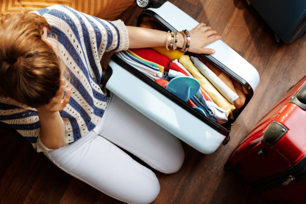 istock stressed elegant woman near over packed suitcase 1155566943