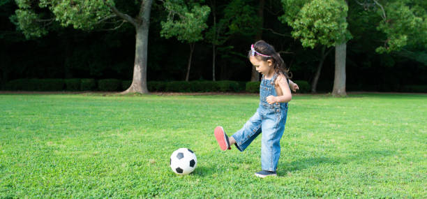 chica jugando con una pelota de fútbol - ball horizontal outdoors childhood fotografías e imágenes de stock