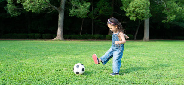 サッカーボールで遊ぶ女の子 - ball horizontal outdoors childhood ストックフォトと画像