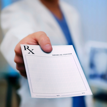 Doctor holding an medical Rx out to the camera. Square shot.