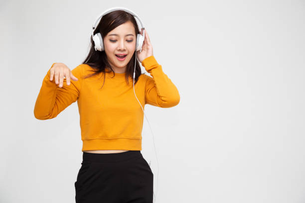 joven de belleza asiática escuchando música con auriculares en la aplicación canción lista de reproducción en el teléfono inteligente aislado sobre fondo blanco - samba dancing audio fotografías e imágenes de stock