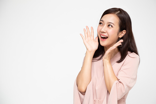 Portrait of excited screaming young asian woman standing in red dress isolated over white background, Wow and surprised business woman concept