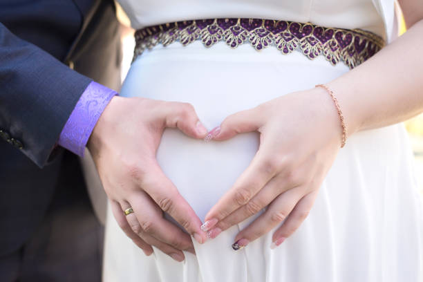 istock the parents hold hands on the tummy heart 1155578192