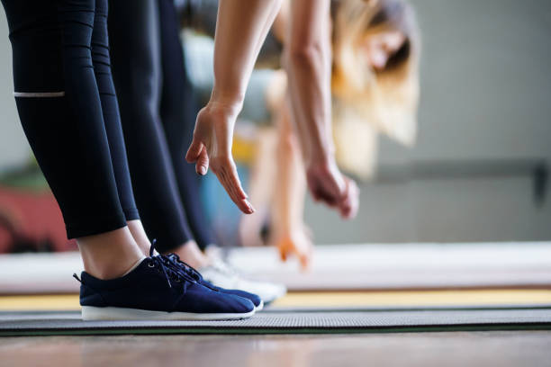 istock Women hands stretching to toecaps on group workout 1155580235