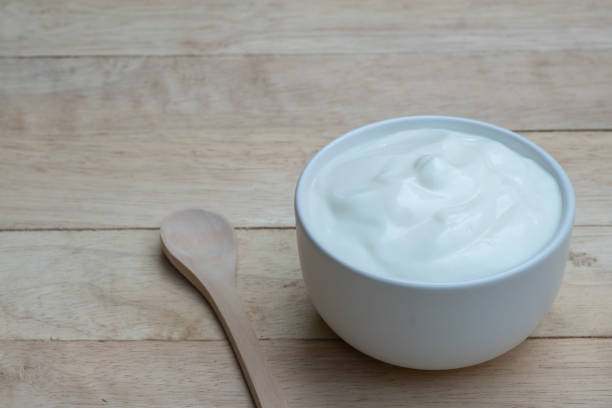 istock Natural homemade plain organic yogurt in ceramic bowl on wood texture background, copy space 1155580378