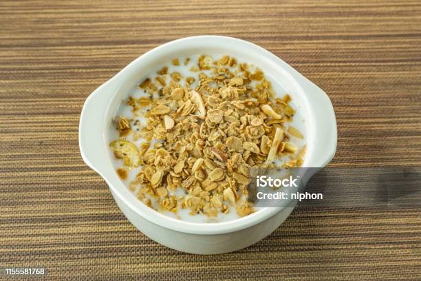 Mañana Los Alimentos Copos De Almendras Y Leche En Un Tazón Blanco Sobre Mesa De Madera Foto de stock y más banco de imágenes de Alimento