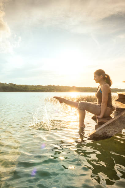 istock Millennial Multi-Ethnic Teen on Dock Splashing Water with Bare Foot 1155583279