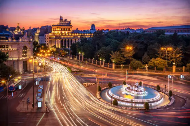 Aerial view of Madrid skyline at dusk with car light trail around cibeles fountain. Madrid, Spain
