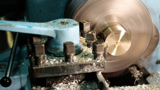 istock Facing operation of a brass blank on turning machine with cutting tool.Old turning lathe machine in turning workshop.Operator machining high precision mold part by cnc lathe 1155585387