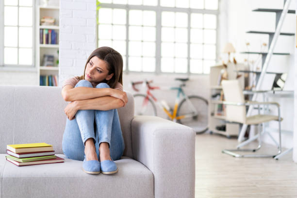 istock Tired woman sitting on a sofa at home 1155585429
