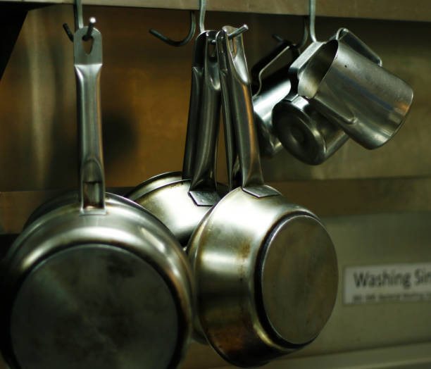 istock kitchen utensils, pans and pots hanging with hooks 1155585526