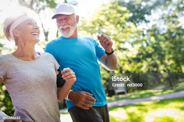 Beautiful Mature Couple Jogging In Nature Living Healthy Stock Photo - Download Image Now