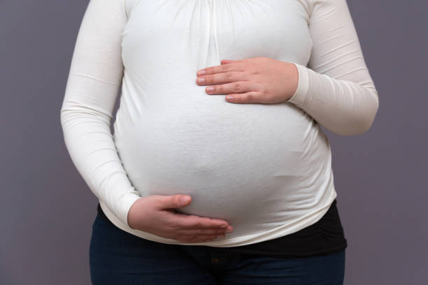 istock Expectant Mom Holding Growing Baby Bump 1155594755