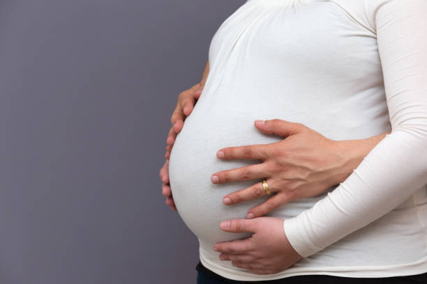 istock Expectant Parents Holding Growing Baby Bump 1155594765