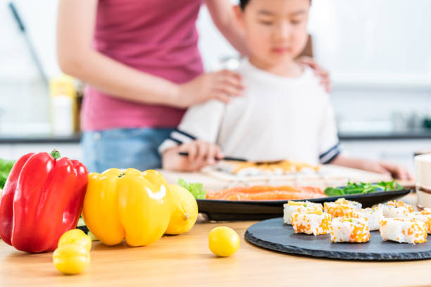 istock Little boy and mother making Hand Roll Sushi 1155595313