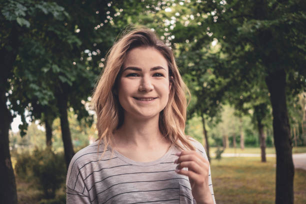 istock Happy friendly young blond woman in a park 1155595480
