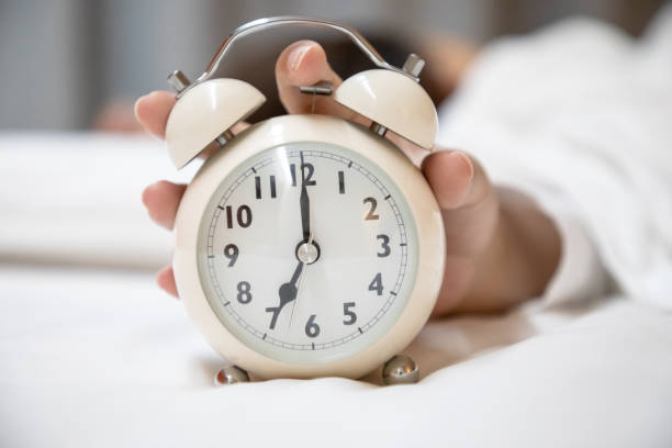 istock Woman pressing alarm clock 1155597329