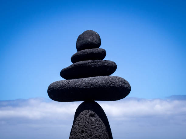 Volcanic rocks in balance on the beach, under clear blue sky