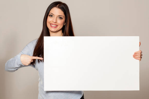 istock Happy woman showing empty blank paper card sign with copy space for text 1155602772