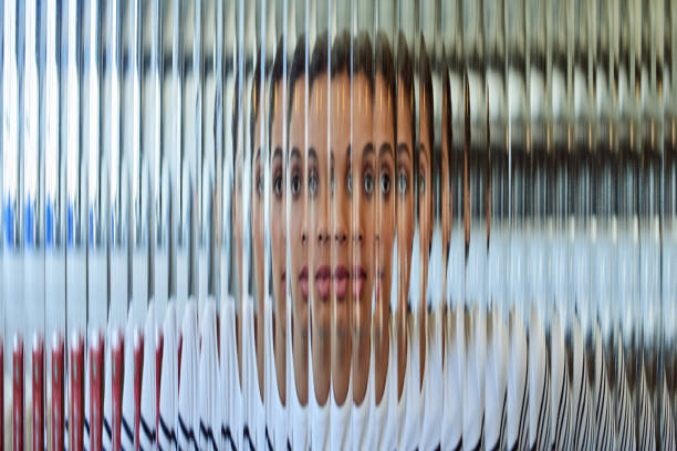 Shot of a beautiful young woman posing behind a glass surface