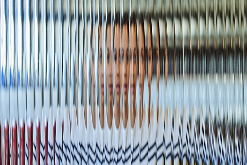 Shot of a beautiful young woman posing behind a glass surface