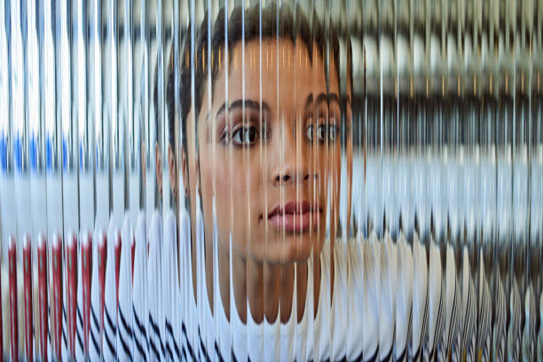Shot of a beautiful young woman posing behind a glass surface