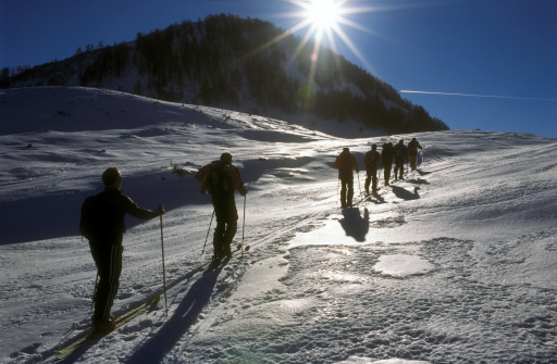 A group of skiers climbs up a mountain in the Austrian alps.