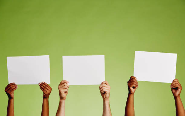 three pairs of hands hold up blank sheets of paper - hand raised arms raised multi ethnic group human hand imagens e fotografias de stock