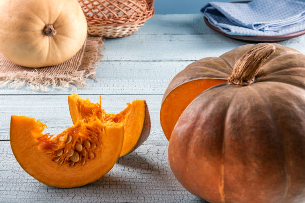 istock Pumpkins and slices with seeds on blue background 1155608965