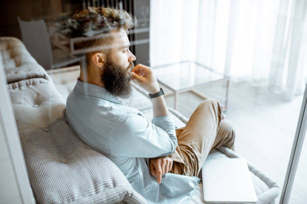 istock Man on the couch at home 1155609903