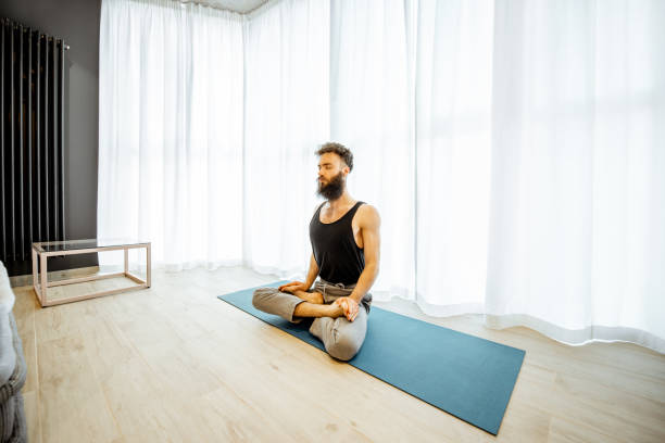 istock Man doing yoga at home 1155609964