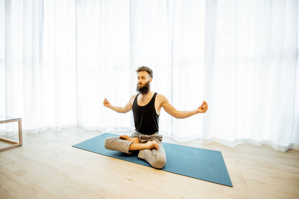 istock Man doing yoga at home 1155610005
