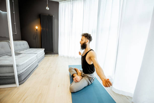 istock Man doing yoga at home 1155610019