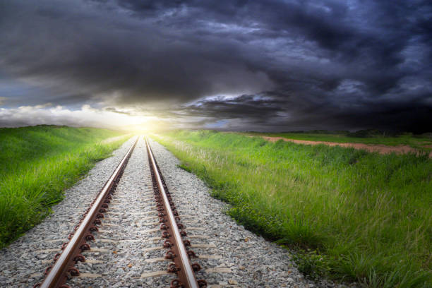 Fantasy landscape railroad tracks on stone around with grass to the light and cloudy sky design