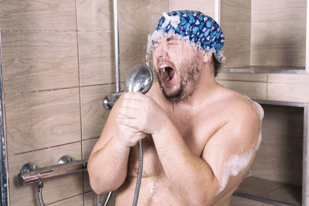 変な太った男がシャワーで歌います。 - 歌う ストックフォトと画像