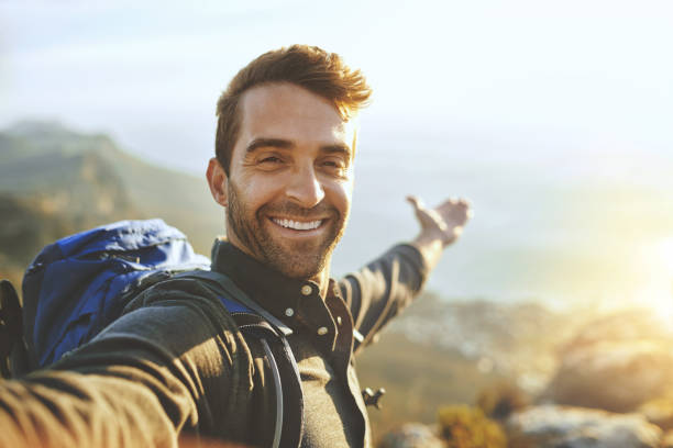 This...is what it's all about Shot of a young man taking selfies while hiking up a mountain mountain climbing photos stock pictures, royalty-free photos & images