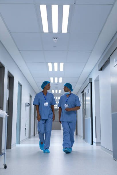 istock Surgeons talking with each other while walking in the corridor at hospital 1155614341