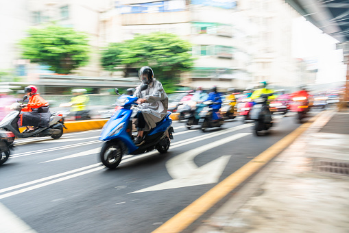 Horizontal color image of very large group of scooters riding on Taipei Streets.