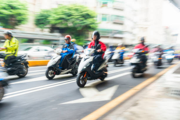 Horizontal color image of very large group of scooters riding on Taipei Streets.