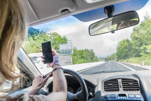 istock Careless Woman Using Phone while Driving a Car on a Highway 1155615532