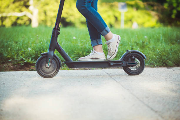 istock Woman riding motor scooter at park 1155619058
