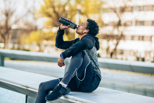 sportivo a riposo - drinking men water bottle foto e immagini stock