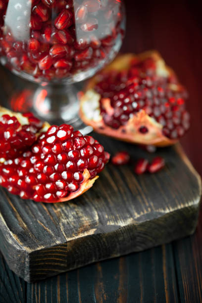 istock Ripe pomegranate fruit on a old black wooden vintage background. Selective focus. 1155622708