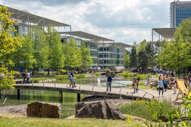 Modern offices in a business park, situated around a pond Modern offices in a business park, situated around a pond. Beautiful landscaping. Pedestrian bridge in the foreground. Photo was taken in Chiswick, London chiswick stock pictures, royalty-free photos & images